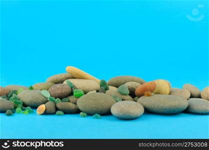 Pebble and sea glasses. On a bright blue background