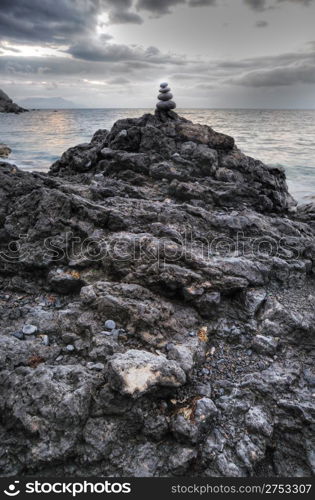 Pebble and stones on a background of the drama sky. Coast of the black sea Crimea, Ukraine