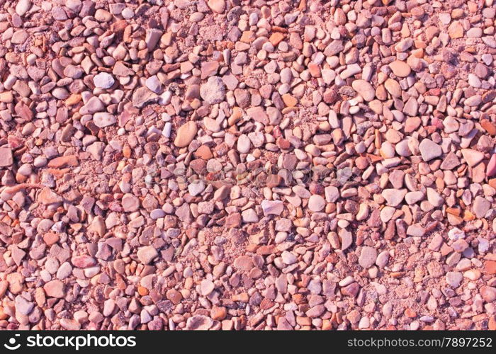 Pebble background at sun light. Stone texture.
