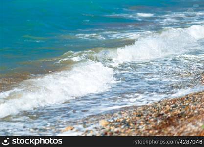 pebble beach and small waves of the Aegean Sea