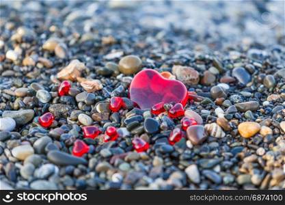 Pebble stones on the beach. Background of sea stones. stones with hearts. Red heart of the stones