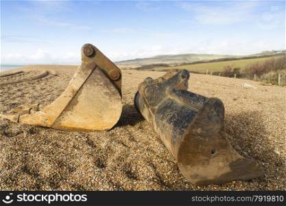 Pebbled beach with two industrial digger scoops, Dorset, England, United Kingdom, Europe