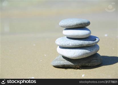 Pebbles stacked on a sandy beach