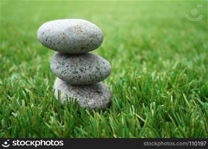 Pebbles stacked up on grass background. Natural concept