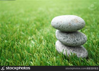 Pebbles stacked up on grass background. Natural concept