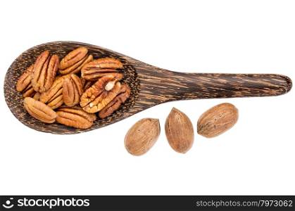 pecan nuts - shelled pecans on a wooden shell with three nuts in shells