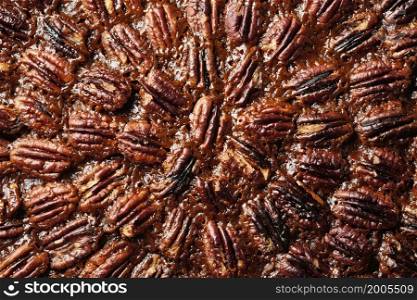 Pecan pie or tart with pecan nuts, close up. Traditional holiday dessert for Thanksgiving or Christmas