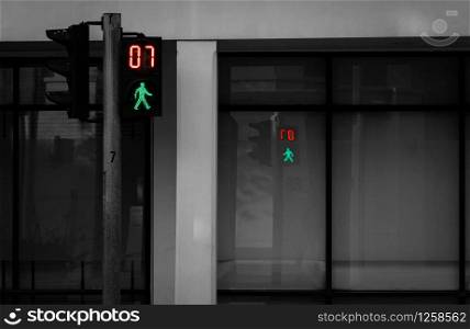 Pedestrian signals on traffic light pole. Pedestrian crossing sign for safe to walk in the city. Crosswalk signal. Green traffic light signal and 7 seconds left to walk across the road.