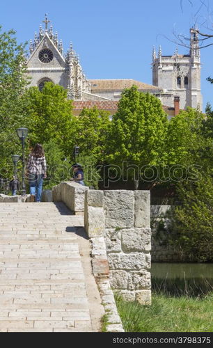 Pedestrian stone bridge, with church in the background in the town of Palencia, Spain