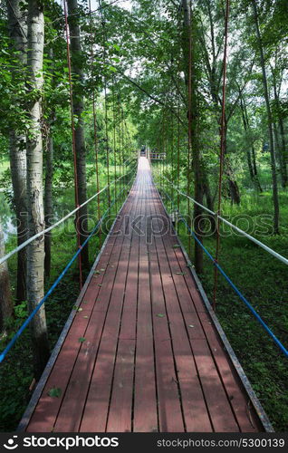 Pedestrian suspension bridge over the river in the park