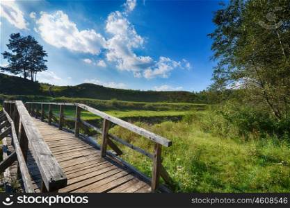 Pedestrian wooden bridge over fields and river