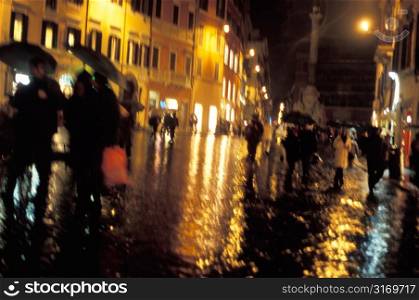 Pedestrians Walking In A Rainy Square