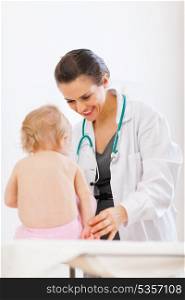 Pediatrician doctor playing with baby on survey