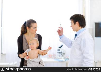 Pediatrician doctor with syringe, tense mother and unhappy baby&#xA;