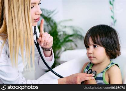 Pediatrician examining little boy with stethoscope