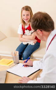 Pediatrician is examining his little patient sitting on a couch and makes some notes