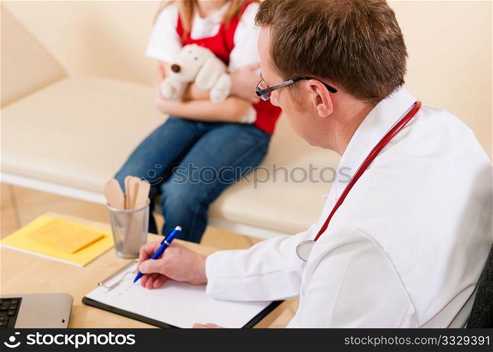 Pediatrician is examining his little patient sitting on a couch and makes some notes