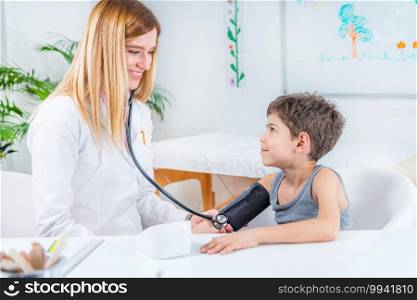 Pediatrician measuring boy’s blood pressure 