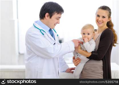 Pediatrician playing with baby on examination&#xA;