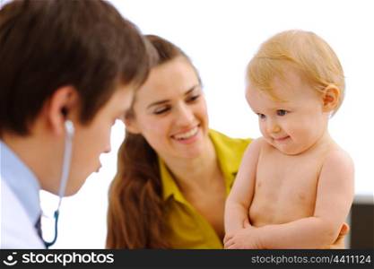 Pediatrician playing with hesitating baby on examination&#xA;