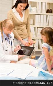 Pediatrician point at tablet x-ray girl broken leg medical office
