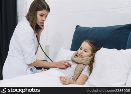 pediatrician woman examining little sick girl with stethoscope