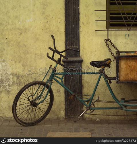 Pedicab chained to a window railing, Havana, Cuba