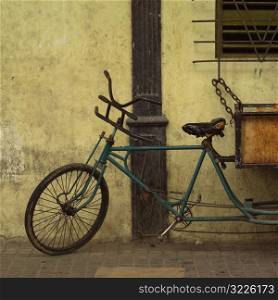 Pedicab chained to a window railing, Havana, Cuba