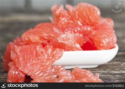 Peeled and crushed red ripe grapefruit ready for nutrition. Peeled grapefruit table pulp