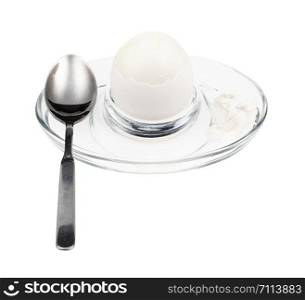 peeled boiled white egg and spoon in glass egg cup isolated on white background