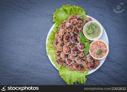Peeled cockles with seafood sauce and vegetable salad lettuce on plate wooden background, Fresh raw shellfish blood cockle ocean gourmet seafood in the restaurant, sea shells food