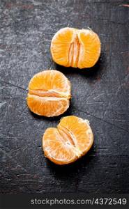 Peeled tangerines. Against a dark background. High quality photo. Peeled tangerines. Against a dark background.