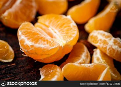 Peeled tangerines. Against a dark background. High quality photo. Peeled tangerines. Against a dark background.