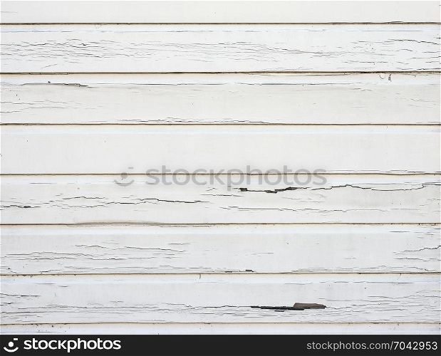 peeling white paint on horizontal wooden planks of shed wall