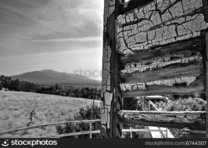 Peeling window shutter and distant city view. Black and white.