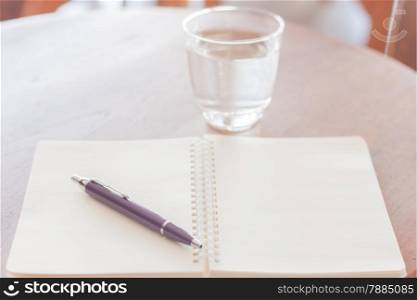 Pen and blank spiral notebook on wooden table, stock photo