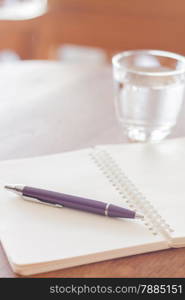 Pen and blank spiral notebook on wooden table, stock photo