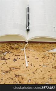 pen and diary on cork wood