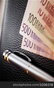 Pen and Euro currency on a wallet
