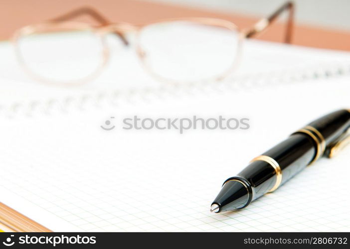 Pen and eye glasses on the page