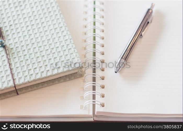 Pen and green cover notebook with spiral notebook