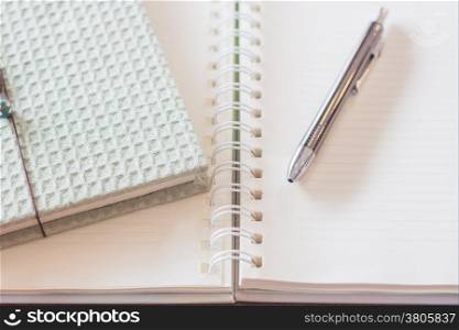 Pen and green cover notebook with spiral notebook