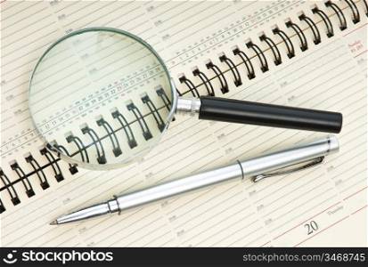 pen and magnifying glass on the calendar