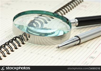 pen and magnifying glass on the calendar