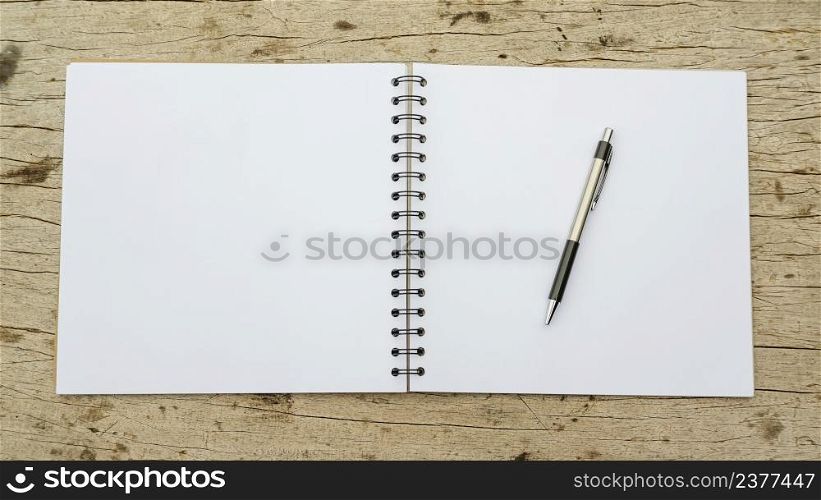 Pen and notebook on a wooden background.