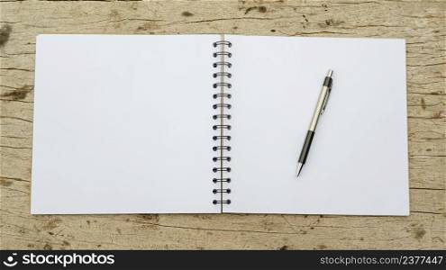 Pen and notebook on a wooden background.