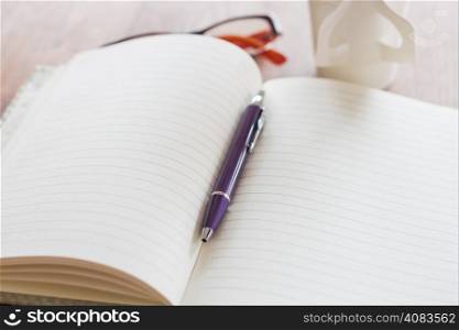 Pen and notebook on wooden table, stock photo