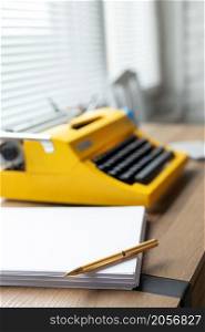 Pen at stack of paper and vintage old typewriter on wood desk table. Writer or study creative