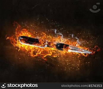 Pen burning in fire. Automatic pen in fire flames on dark background