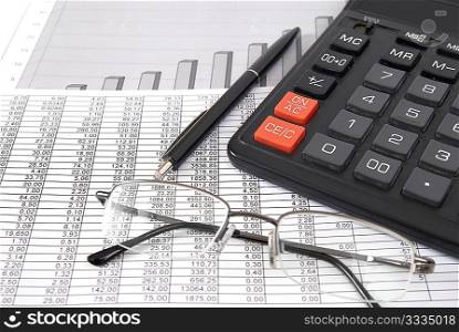 Pen, glasses and calculator on paper table with finance diagram